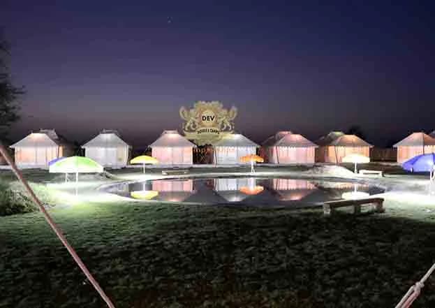 Tents around the lit Talai pond at dusk